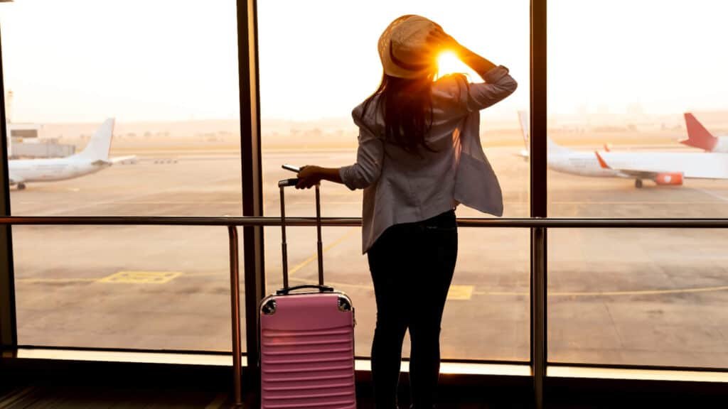 Woman-at-airport-looking-out-windows.-Image-credit-Nok-Lek-Travel-Lifestyle